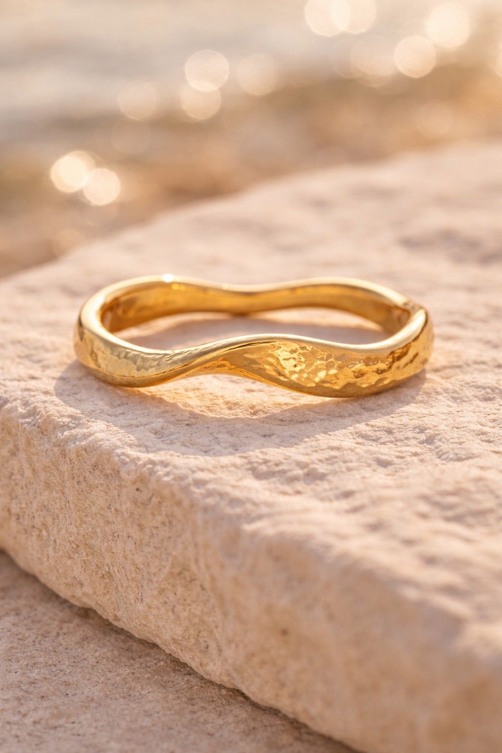 Bague alliance vague or, sur un rocher, plage